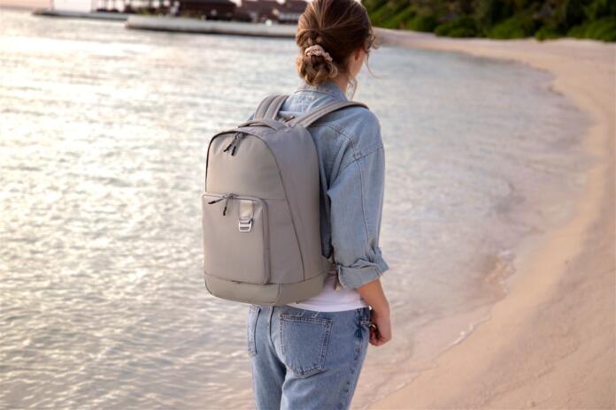 Mulher a usar uma mochila da samsonite numa praia