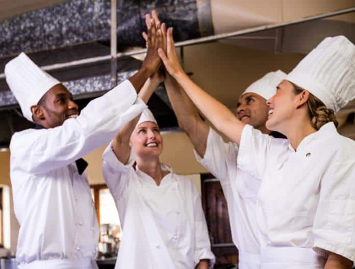 group-of-chefs-formig-hands-stack-in-kitchen-at-ho-3ABKL8D (1)