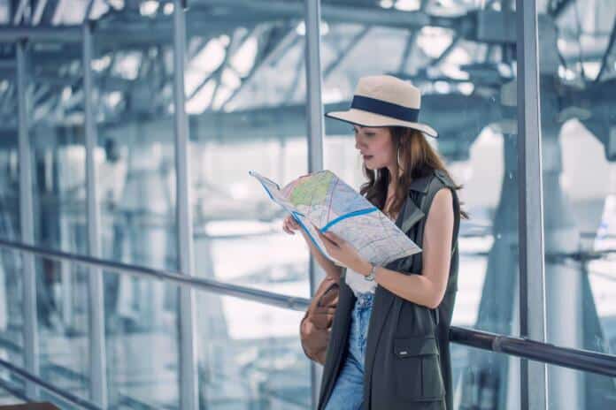 Asian,Women,,Beautiful,Standing,Read,Map,And,Search,Destinations,Plan